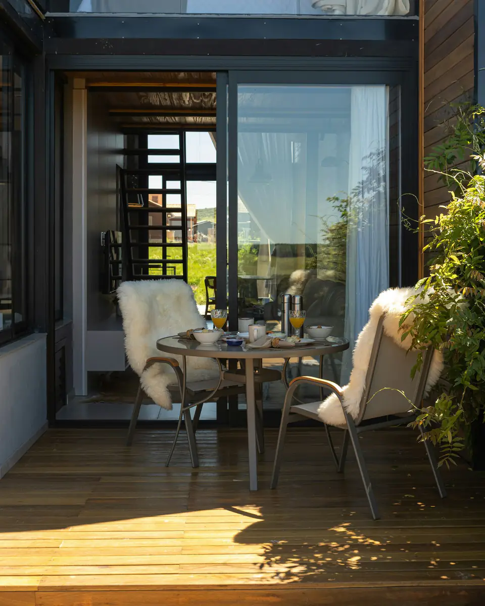 Mesa de desayuno en el deck, con sillones y plantas