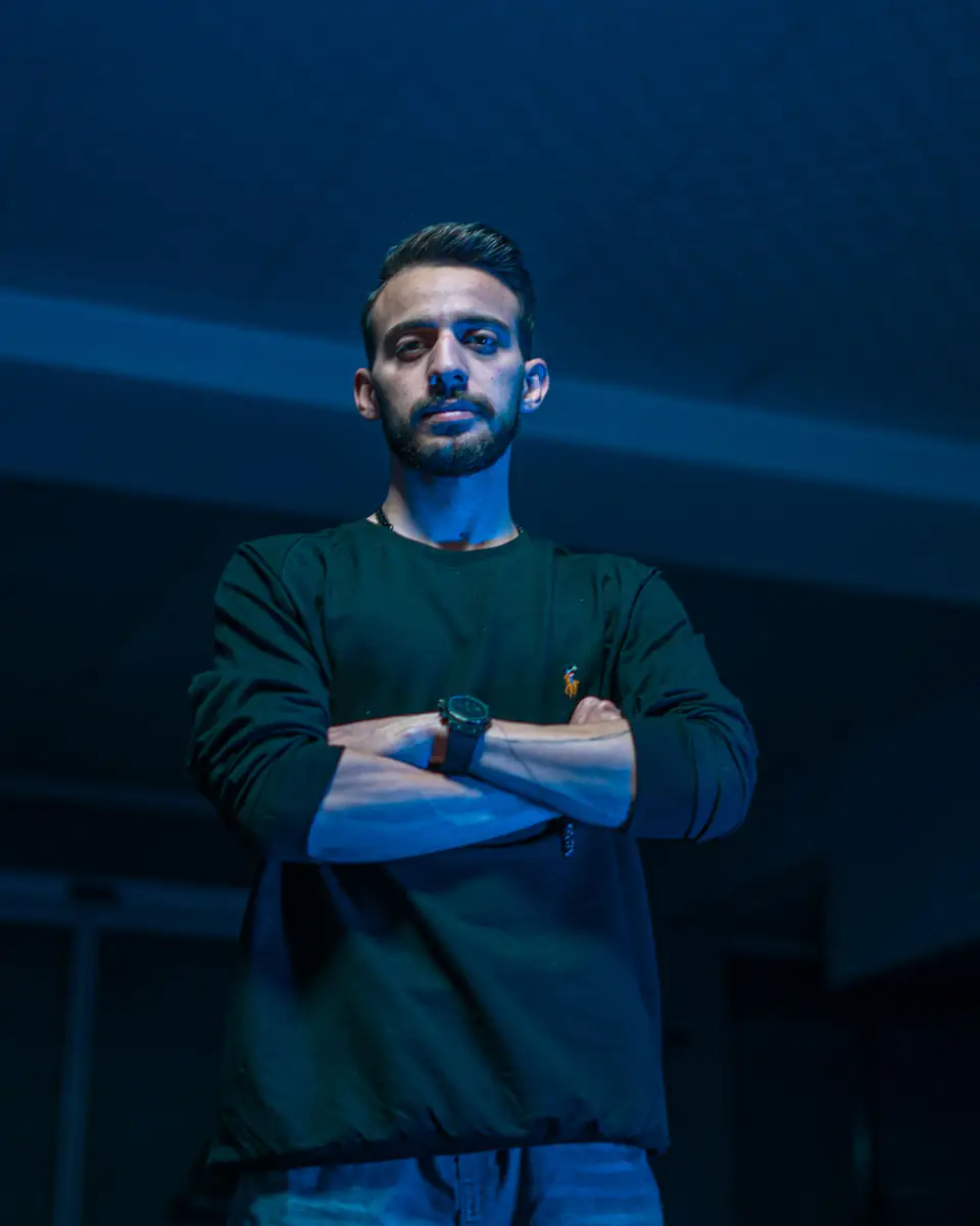 Diego, de brazos cruzados con luz azul de fondo