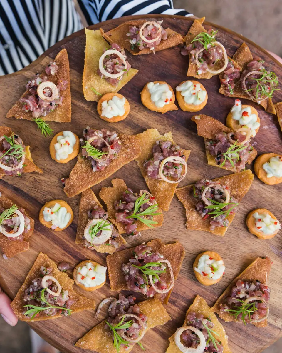 Una tabla de madera con bocaditos variados para la recepción