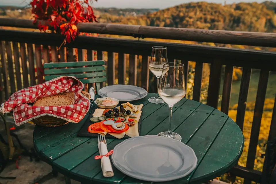 Mesa con copas y una picada en un balcón al atardecer