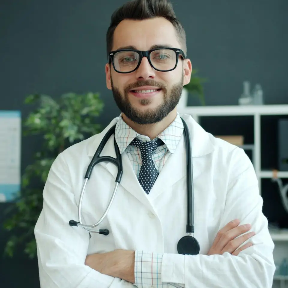 Retrato del doctor Federico Cabrera, sonriente, de brazos cruzados
