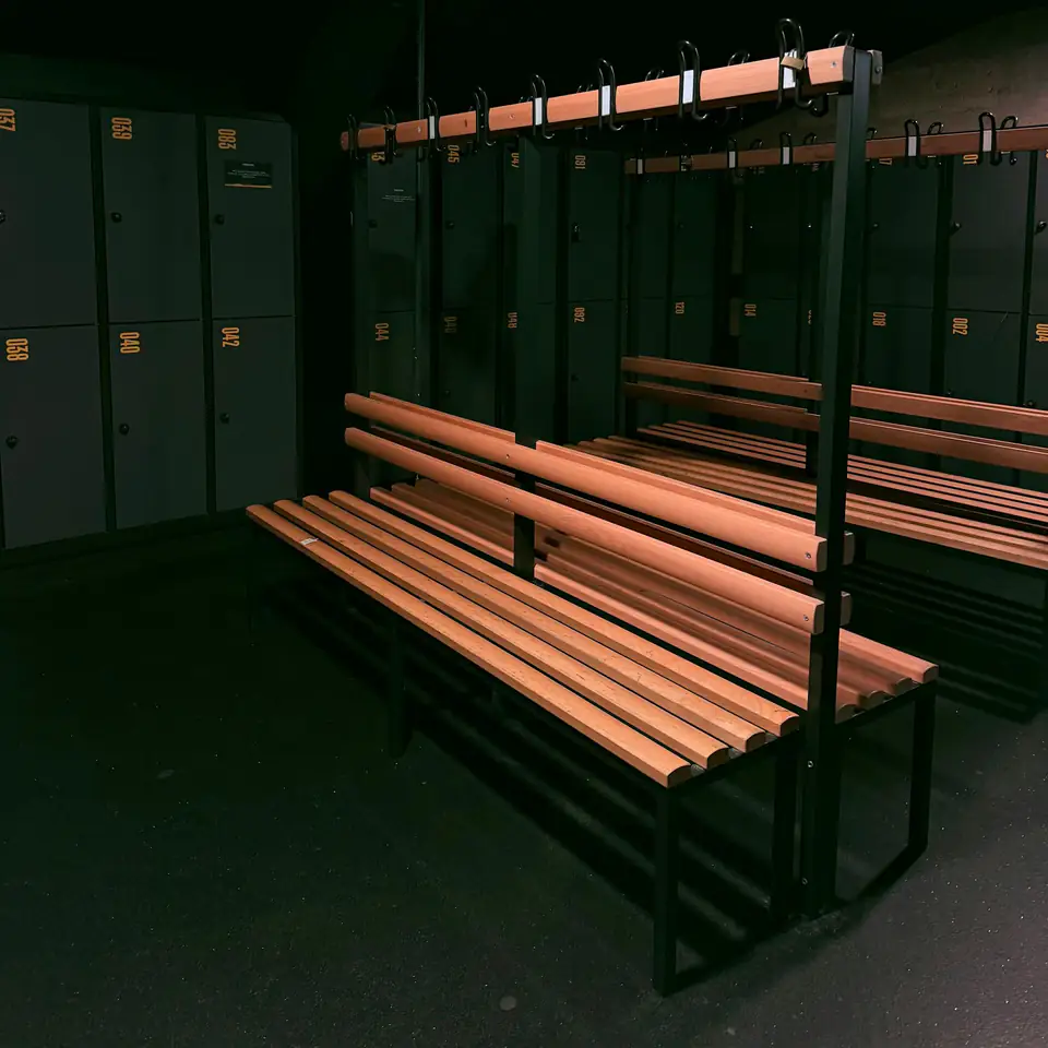 Vestuario con bancos de madera y lockers