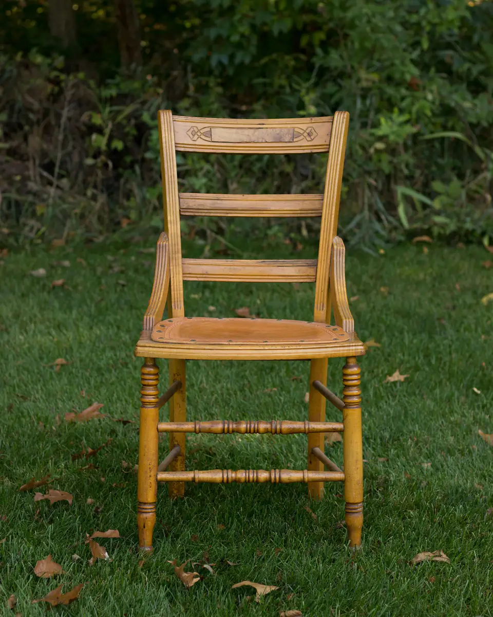 Silla de madera restaurada, con lustre natural, sobre el pasto